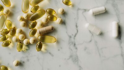 A variety of capsules and pills scattered on a marble surface, offering a modern healthcare concept.