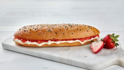 a sandwich with a strawberry on a marble platter