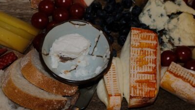 Assortment of cheeses, bread, and fruits on a board