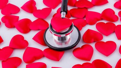 a stethoscope surrounded by hearts on a white surface