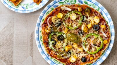 pizza with green and brown sauce on white ceramic plate
