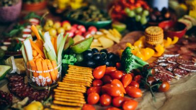 Vibrant display of fresh fruits, vegetables, crackers, and meats perfect for a party platter.