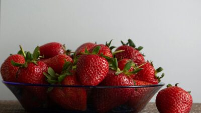 A vibrant close-up image of ripe red strawberries in a glass bowl, perfect for summer themes.