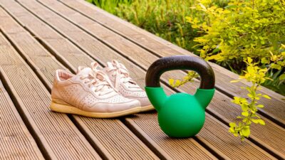 a pair of shoes sitting on a wooden bench next to a watering can