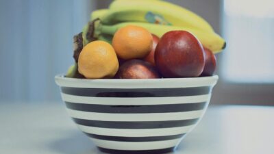 A vibrant assortment of fresh fruits in a striped bowl, ideal for healthy living.