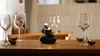 An intimate dining scene with elegantly arranged empty wine glasses and a candlelit ambiance.