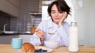 a woman sitting at a table with a plate of food
