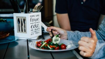 a couple of people sitting at a table with a plate of food