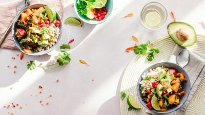 Top-down view of vibrant vegan bowls filled with fresh vegetables, perfect for a healthy meal.