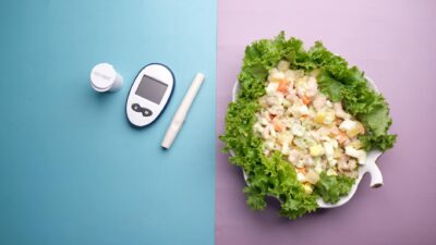 Top view of diabetes equipment and fresh salad representing healthy living.