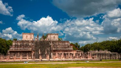 Explore the iconic Mayan ruins of Chichén Itzá in Yucatán, Mexico under a vibrant blue sky.