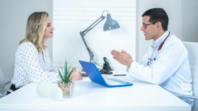 A doctor conducts a patient consultation in a bright, modern medical office.