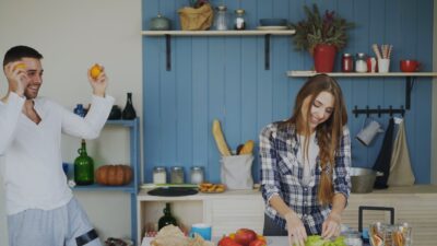 Couple happily preparing food and dancing in kitchen