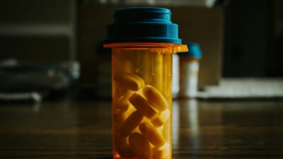 a bottle filled with pills sitting on top of a wooden table