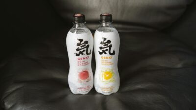 Close-up of Genki flavored sparkling water bottles placed on a leather couch, showcasing packaging and design.
