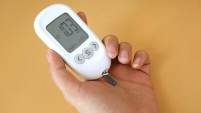 Close-up view of a blood glucose meter in hand measuring glucose levels.