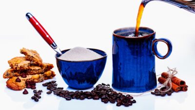 blue ceramic mug with red and yellow handled scissors