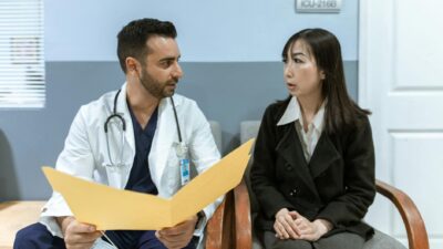 Healthcare professional consults patient in clinical setting. Medical discussion and diagnosis.