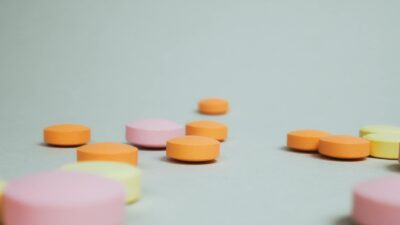Close-up of colorful round tablets arranged randomly on a neutral surface.