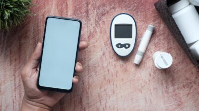 a person holding a smart phone next to an electronic device