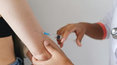 Doctor administering an injection to a patient's arm, close-up view.
