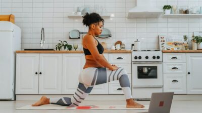 Adult woman practices yoga indoors, focusing on healthy lifestyle and flexibility.