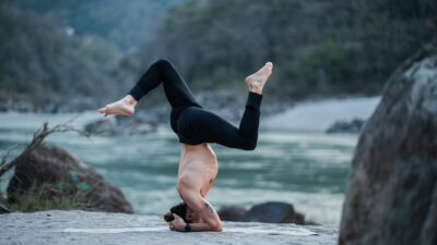 a woman doing a handstand on a beach