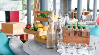 Outdoor table with fresh fruit, glass bottles, and juice shots.