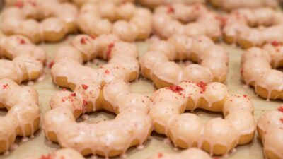 Close-up of delicious glazed mochi donuts topped with strawberry pieces, offering a sweet treat delight.