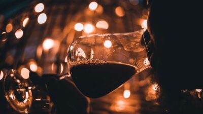 person holding wine glass with red wine