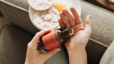 person holding red bottle