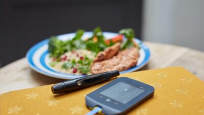 a plate of food and a Glucometer on a table