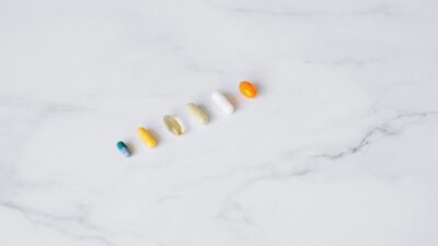 Aerial view of assorted capsules arranged on a white marble surface.