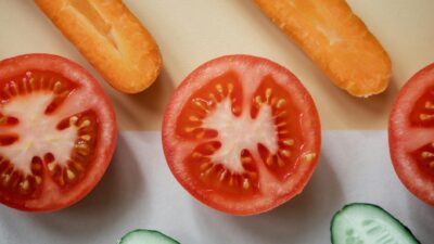 Colorful flat lay of sliced carrots, tomatoes, and cucumbers, highlighting fresh and healthy food choices.