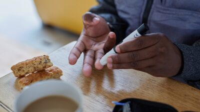 a person doing a finger prick test for blood glucose