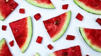 Fresh slices of watermelon arranged on a white background for food photography.