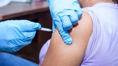 Close-up shot of a healthcare professional giving a vaccine injection.