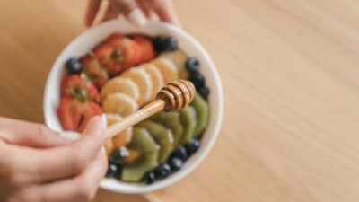 Close-up of a fresh fruit salad with a honey drizzle being added, capturing vibrant colors and textures.