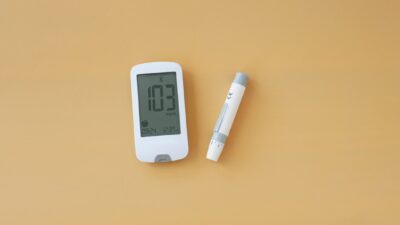 a thermometer and a pen on a yellow surface