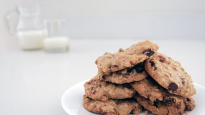 Cookies are stacked on a plate with milk.