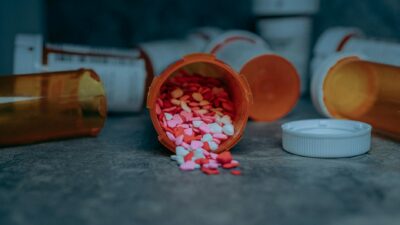 Colorful pills spilling from a prescription bottle on a counter in Portland, OR.