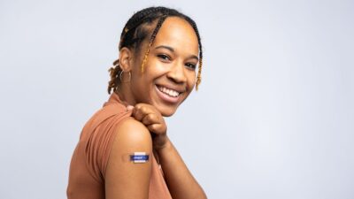 a smiling woman with braids on her hair
