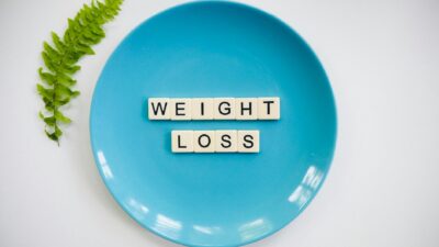 A blue plate with 'weight loss' tiles and a fern leaf on white background.