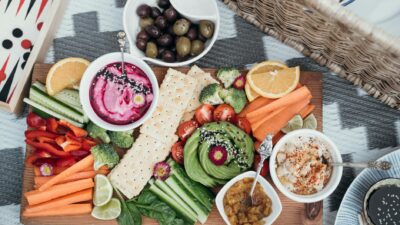 Colorful vegan platter featuring fresh vegetables, dips, and olives. Perfect for a healthy snack or party.