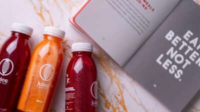 three bottles of juice next to a book