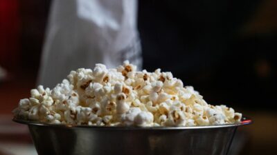 A metal bowl overflowing with freshly popped popcorn