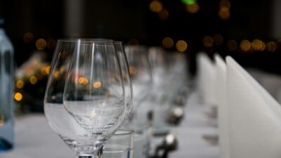 Close-up of sparkling wine glasses elegantly arranged on a formal dining table, creating a warm and inviting atmosphere.