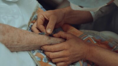 A healthcare professional administers an injection to an elderly patient in a hospital setting.