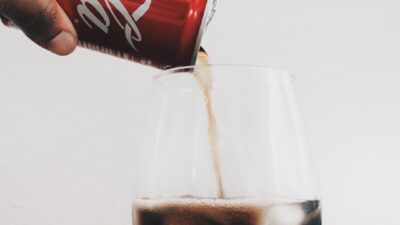 time lapse photography of person pouring can of Coca-Cola in wine glass