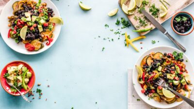 three bowls of salad dish with lemon on table